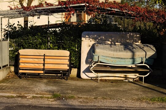 A Series Of Mattresses Stacked And Abandoned On The Side Of An Alphalt Road (Pesaro, Italy, Europe)