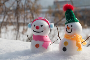 cute snowman standing on snowy field in winter.