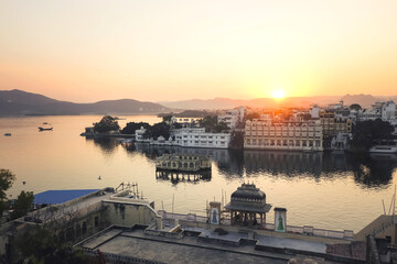 View of the Pichola Lake with sunset in Udiapur, Rajasthan, India. white City in Rajasthan