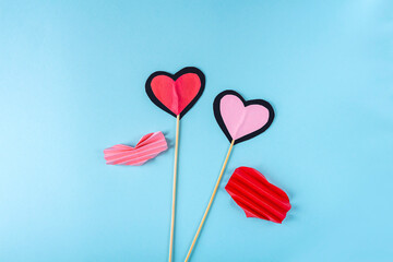 Fototapeta na wymiar DIY and kid's creativity. Step by step instruction: how to make paper valentine heart on wooden stick. Step6 glue wood sticks between two hearts. Craft for Valentines day.