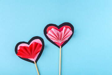 DIY and kid's creativity. Step by step instruction: how to make paper valentine heart on wooden stick. Step7 turn off and glue heart like accordion to  hearts on stick. Craft for Valentines day.