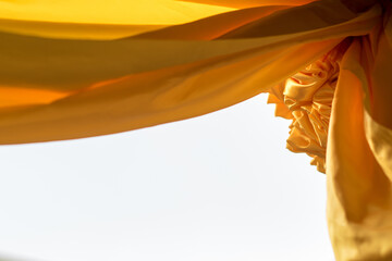 Yellow sateen rolls and hanging to decorate the arch