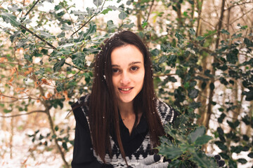 Young woman portrait between trees covered with snow