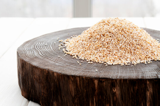 Coarse barley grits on a round wooden board