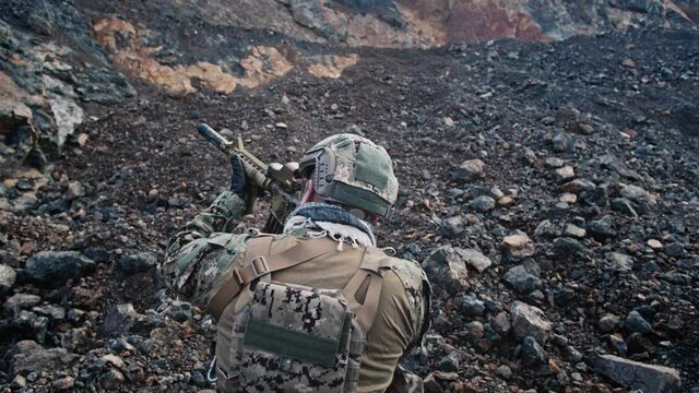  A US Marine positioned in th mountain gorge takes aim with his rifle. 