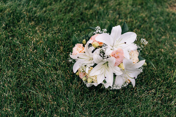 Obraz na płótnie Canvas wedding bouquet with lilies, hydrangeas and roses lies on green grass