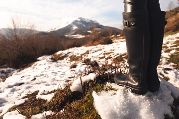 Woman high boots at a snowy mountain