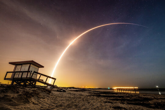 Rocket streaks above the Beach at Night though the Stars