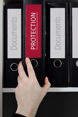 Protection. Folder with label on the shelf of a lawyer. Red label with text in focus.