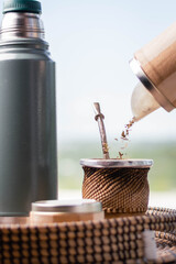 close-up of mat wood and yerba bulb and water at 80 degrees of hot temperature with thermos foam...