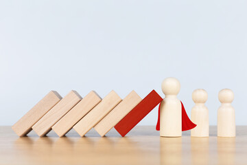 Wooden figurines representing leader stopping the domino falling over the employees. Business strategy