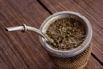 close-up of mat wood and yerba bulb and water at 80 degrees of hot temperature with thermos foam yerbera sugar bowl rustic wood base cordoba argentina