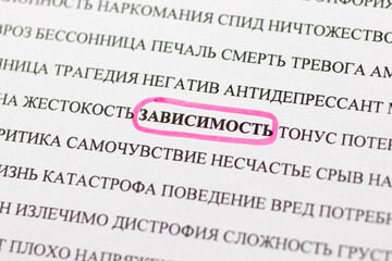 Highlighting the word dependence pink marker in the newspaper, translation from Russian: negative,...