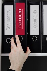 T-Account. Folder with label on the shelf of a lawyer. Red label with text in focus.