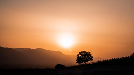 Fototapeta premium Sunset over the mountains and meadow