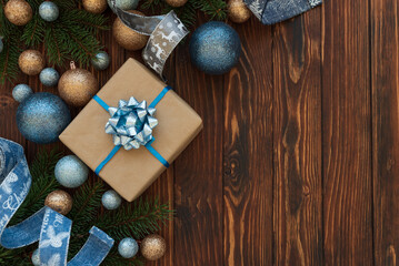 Christmas composition. Christmas present box, balls, blue and silver decorations on blue wooden background. Flat lay. Top view. Copy space