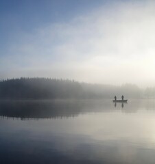 Fototapeta na wymiar boat in water with foggy sunset