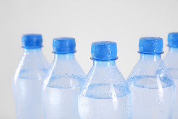 Plastic bottles with pure water on white background, closeup