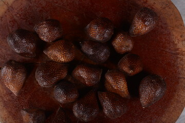 pile of fresh salak fruit with wooden background, fruit photo concept.