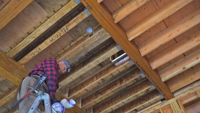29 SEPTEMBER 2020 Philadelphia PA USA: Worker using glue with fitting for installing the PVC drain pipe in the work area.