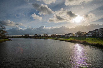 Fototapeta premium view from bride to dike and beautiful werdersee, a river in bremen, in the sun with amazing sky