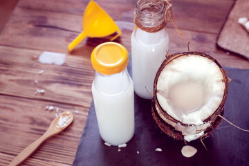 coconut, two bottles with coco milk and funnel