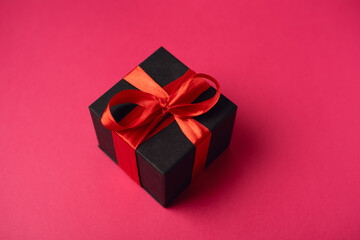 Black gift boxes with red ribbon on hot pink background. The Concept Of Valentine's Day.