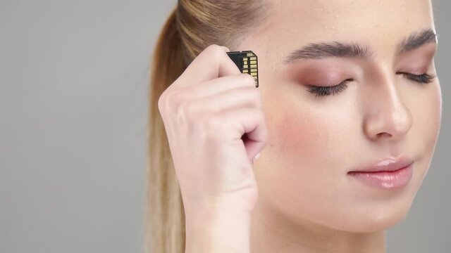 close-up of woman plugs in micro sd card to her head