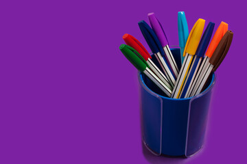 colored pens in a purple penholder