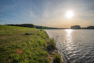 green field at beautiful werdersee, a river in bremen, at sunset