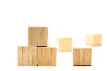 A photo of four brown wood blocks. On a white background On the left side of the picture there are three wooden blocks. On the right side of the picture there is one block. And on the back there are t