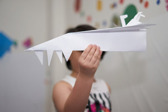 Boy holds paper fold rocket for imagine concept