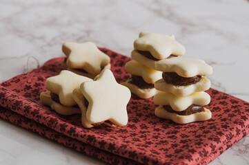 Star shaped cookies with chocolate fudge. Red cloth, marble