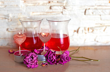 Obraz na płótnie Canvas burning candles hearts on the background of a Turkish drink with dried roses, Valentine's day