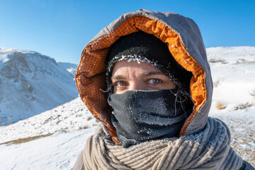 Fototapeta na wymiar Extremely cold weather. Portrait of middle age European woman with face covered with snow frost.