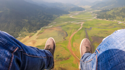 First Person View of Paragliding in Pokhara, Nepal. Legs out against mountainous landscape at an...
