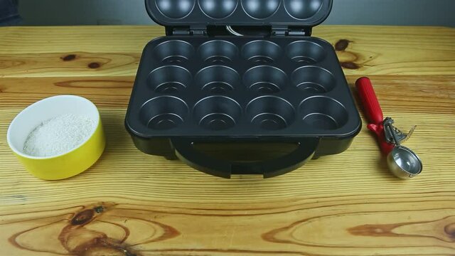 top view at open black backer machine for made muffins served on yellow woden table