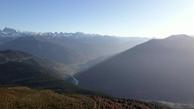 der blick vom berg in ein sch&ouml;nes tal in dem gerade die sonne untergeht