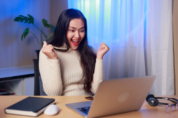 Overjoyed young Asian woman look at laptop screen feel euphoric with online lottery win or success,...