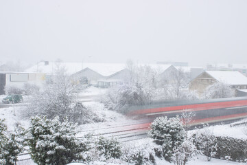 Verschneite Winterlandschaft im Wohngebiet mit Eisenbahn