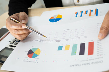 Asian accountant working and analyzing financial reports project accounting with chart graph and...