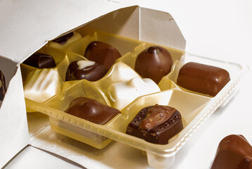 set of different chocolates in open box white background
