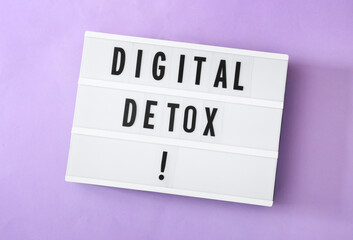 Lightbox with words DIGITAL DETOX on violet background, top view