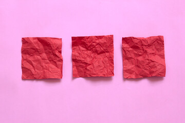 red crumpled sticky note papers on pink background