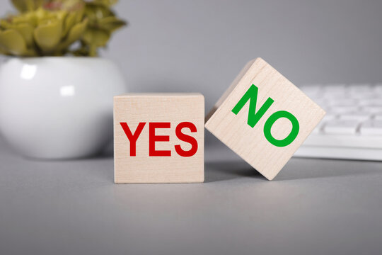 YES NO. Text on wood cubes on a gray background. business concept