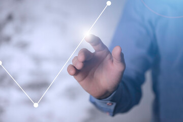 Dłoń dotykająca rosnący wykres. Koncepcja zysku, odbudowy rynku i kapitał&oacute;w