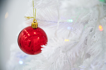 Red Christmas ball toy on a white Christmas tree
