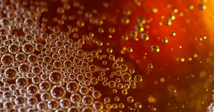 Bubbles floating on a liquid surface. Abstract close up shot of beer, cider or prosecco.
