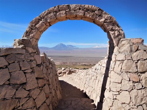 Vue sur les volcans chiliens &agrave; travers une arche en pierre