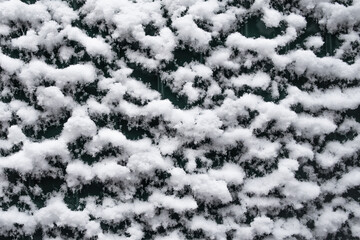 Snow lies on a vertical relief surface 